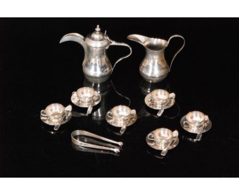 An Egyptian silver coffee service comprising coffee pot, cream jug, six coffee cups and saucers, six teaspoons and a pair of 