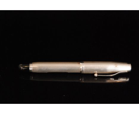 A 1940s hallmarked silver fountain pen with engine turned decoration, vacant cartouche and screw cap with clip, terminating i