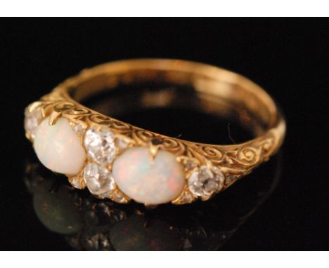 A Victorian 18ct hallmarked opal and diamond boat shaped seven stone ring, two opals spaced by old cut diamonds, Birmingham 1