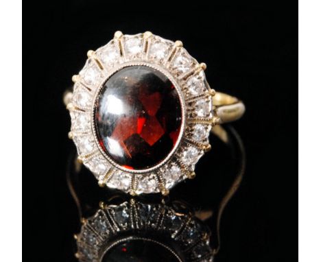 An 18ct hallmarked garnet and diamond cluster ring, central oval collar set garnet to a sixteen stone diamond surround, Birmi