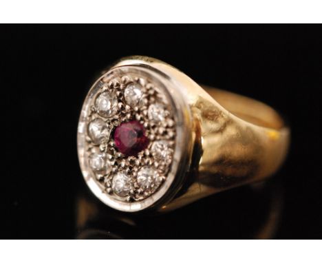 An 18ct hallmarked ruby and diamond cluster ring, central ruby within an eight stone diamond surround, ring size leading edge