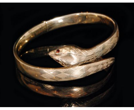 A modern 9ct hallmarked hinged snake bangle with garnet set eyes and part cross hatch decoration, weight 19.5g. 