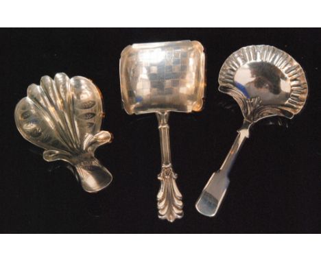 A Victorian hallmarked silver caddy spoon, the shovel shaped bowl with checker board bright cut decoration and stylized fleur