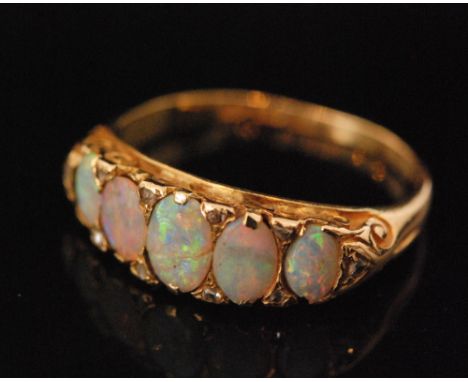 A Victorian 18ct hallmarked graduated five stone opal boat shaped ring, each spaced by two rose cut diamonds, Birmingham 1892