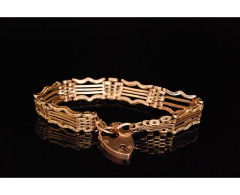 An early 20th Century 9ct rose gold five bar gate bracelet with chased decoration to outer bars, terminating in padlock faste