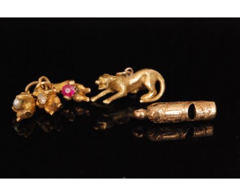 Three gold charms, an early 20th Century whistle, three standing bears with ruby set eyes one holding a diamond, the other a 