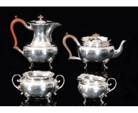 A George V hallmarked silver four piece tea service comprising of teapot, hot water pot, sugar bowl and cream jug, of plain o