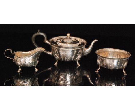 An Edwardian hallmarked silver three piece tea service composed of teapot, sugar bowl and cream jug, of circular outline with