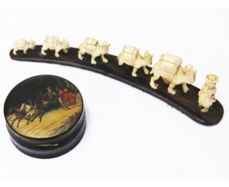 A papier mache snuff box. Diam. 8cm, together with graduated carved ivory elephants on hardwood base. L23cm