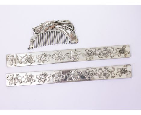 A pair of Chinese white metal scroll rests and a comb