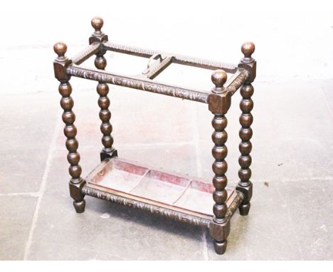 A carved oak stick stand with bobbin turned pillars. L61cm