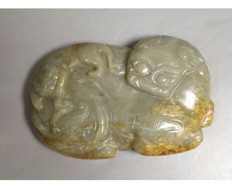 A Chinese celadon and a russet jade ‘lion dog and cub’ plaque, 11.5cm across