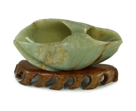 A Chinese green and russet jade ‘lotus leaf’ brushwasher, 17th/18th century, carved as a curled lotus leaf with incised decor