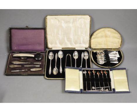 A cased set of six white metal and enamel cocktail sticks and three other cased sets including silver tea and coffee spoons a