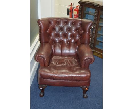 A CHOCOLATE BROWN LEATHER BUTTON BACK ARMCHAIR, on ball and claw feet