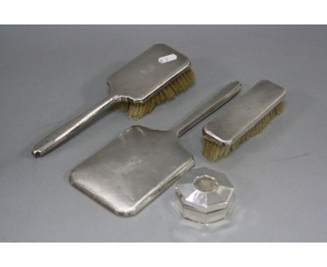 AN ART DECO STYLE THREE PIECE SILVER BACKED DRESSING TABLE SET, comprising hand mirror and two brushes, makers W.N Ltd, Birmi