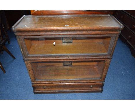 AN OAK GLOBE-WERNICKE TWO SECTIONAL TWO SHELF BOOKCASE, with glazed fall front doors above a single drawer