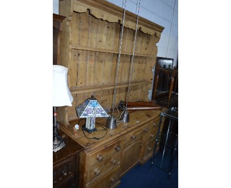A LARGE EARLY 20TH CENTURY PINE KITCHEN DRESSER, with a two tier plate rack above seven various drawers and central cupboard,