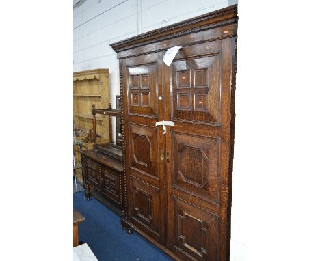 AN EARLY 20TH CENTURY OAK THREE PIECE BEDROOM SUITE, comprising of a large panelled two door wardrobe with four slides and th