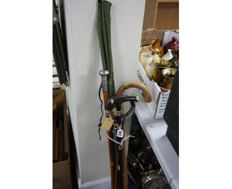 THREE WALKING STICKS, two with silver mounts, a shooting stick and a fishing rod