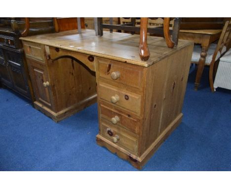 A PINE KNEE HOLE DESK, with five various drawers and a cupboard