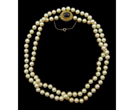 Single strand cultured cream / pink pearl necklace, on a gold cabochon garnet clasp, stamped 9ctCondition Report:Clasp very a