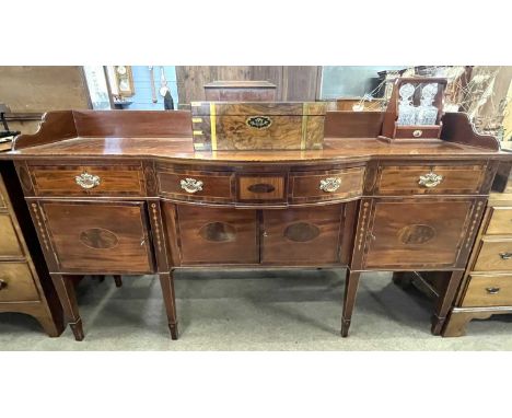 An Irish mahogany and inlaid galleried back sideboard with bow front centre and three drawers and four doors, raised on taper