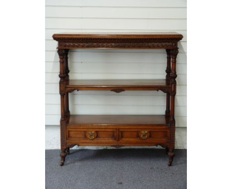 Victorian oak three tier what-not with two drawers under, the ornately carved columns leading to ceramic castors, 107 x 42 x 