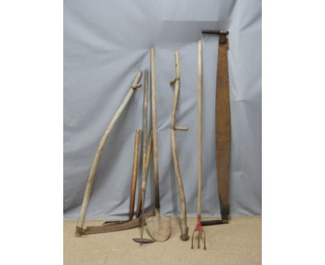 Collection of vintage farming/gardening tools including a scythe, two handled saw etc