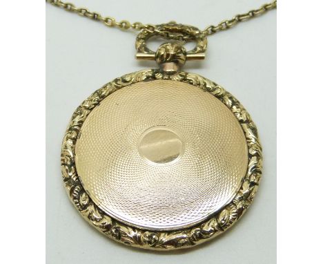 Victorian locket with engine turned decoration and foliate border (4cm diameter, 15g) and a yellow metal chain with textured 