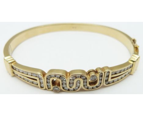 An 18ct gold bangle set with diamonds in an abstract design, 28.7g&nbsp;