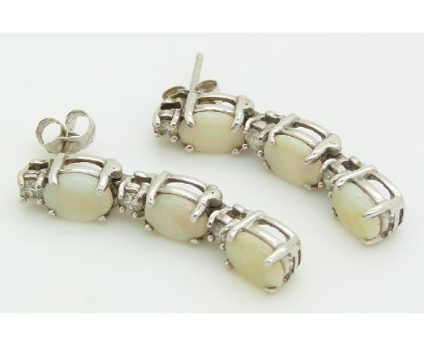 A pair of 14ct white gold earrings set with three opal cabochons to each, 4.9g