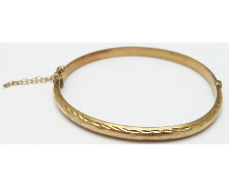 A 9ct gold bangle with cut out decoration, 6.1g