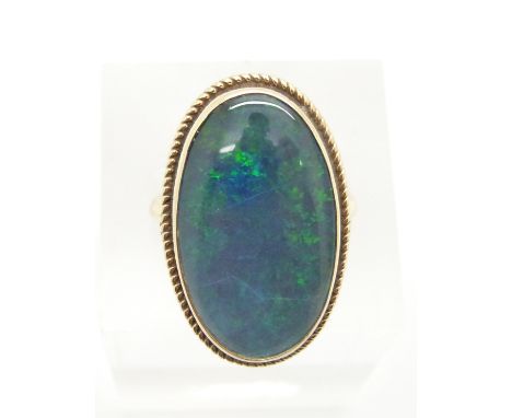 A 9ct gold ring set with an opal triplet within a rope twist border, 6.2g, size L