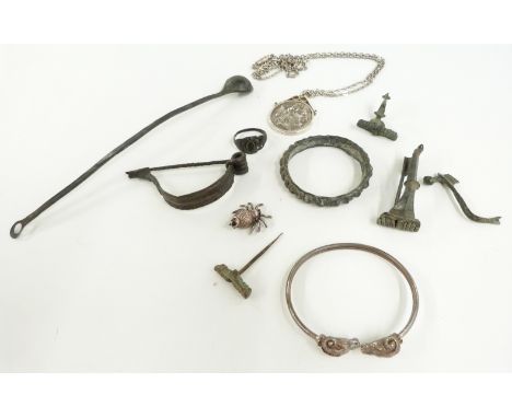 A silver bangle with ram head decoration, silver spider charm, Roman bottle spoon, Roman fibula brooches, Roman ring etc