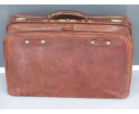 Vintage leather Gladstone bag style suitcase with filled interior and metal trim.