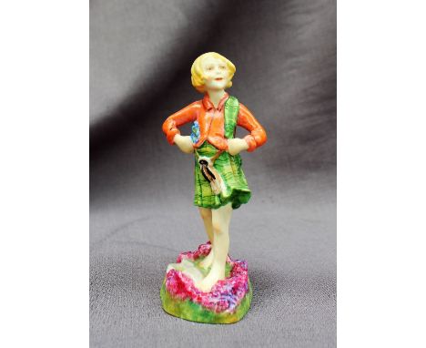 A Royal Worcester figure of a young girl in a kilt, standing on a heather landscape, 14cm high 