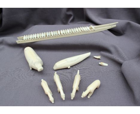 Inuit carved walrus tusk models, including a model husky sled, walrus, whale and bears 