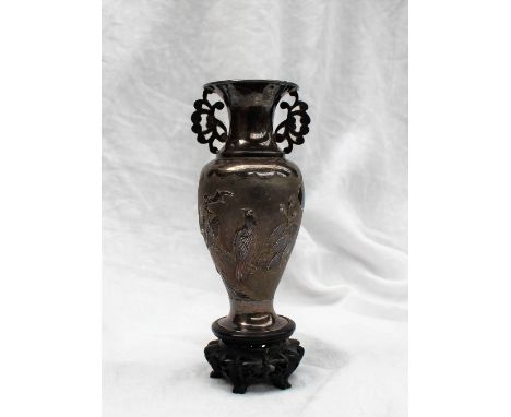 A Chinese silver baluster vase, with floral handles, the body decorated with a bird perched on a branch, with textural charac