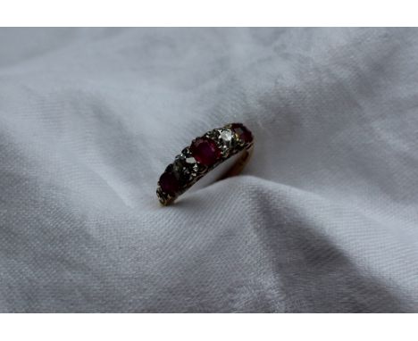 A ruby and diamond line ring, set with three rubies and two round old cut diamonds, to an 18ct yellow gold setting and shank,