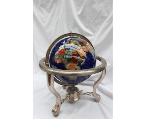 A gem set globe, set with minerals and semi precious stones to depict the countries of the world against an ocean of Lapis La
