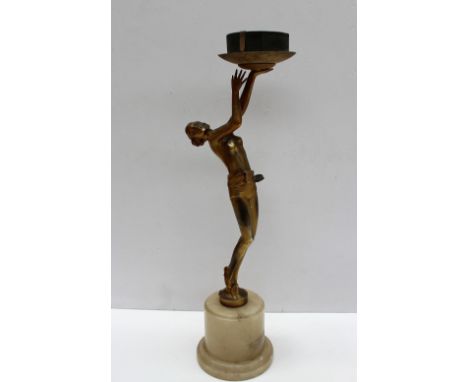 An Art Deco style gilt decorated white metal lamp, in the form of a semi naked maiden holding the shade aloft on an alabaster