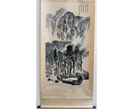 A Chinese scroll picture, painted with a landscape scene with trees and a river in the foreground and mountains beyond with s