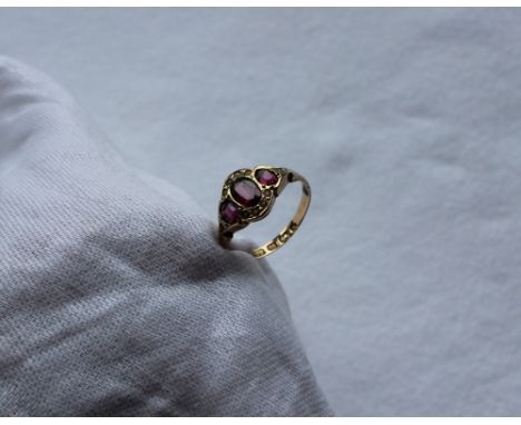 A late 18th / early 19th century 12ct gold ruby and pearl set ring, with three oval rubies surrounded by seed pearls to a 12c