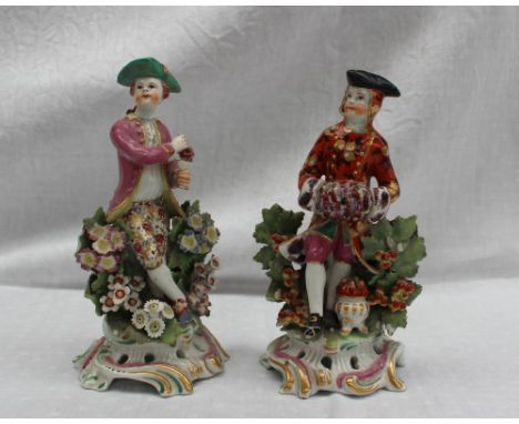 A pair of 18th century porcelain figures, possibly Bow, the one squeezing grapes into a chalice, wearing a tricorn hat, pink 