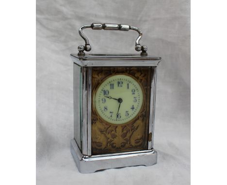 A 20th century French chrome plated carriage timepiece, with an enamel dial and Arabic numerals, with a gilt pierced panel, m