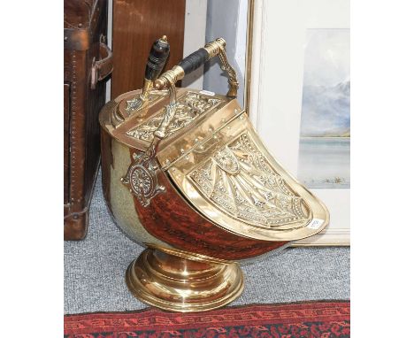 A Brass Coal Helmet and Scoop, 19th century, with embossed decoration and raised on a stepped circular footThe handle loose. 