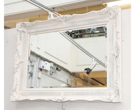 A Modern Cream Painted Mirror, the beveled rectangular plate within a conforming frame decorated with shells and acanthus lea