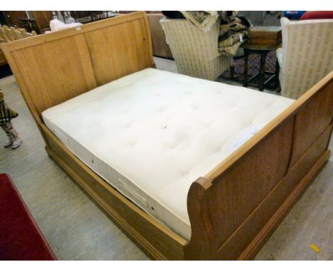 A John Lewis light oak sleigh style bed, having a twin panelled head and footboard, a slatted base and mattress  54''w       