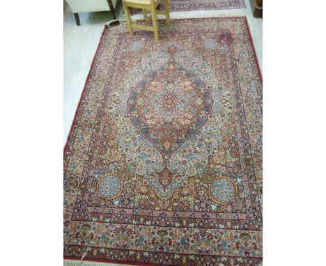 A Super Keshan carpet, having a central serpentine outline diamond motifs, surrounded by stylised flora on a red ground  80''